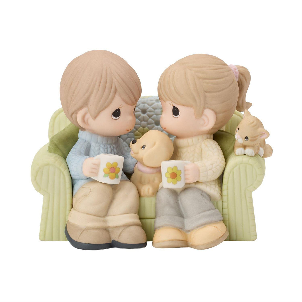 A couple sitting on the couch drinking coffee enjoying each others company along with a dog and cat