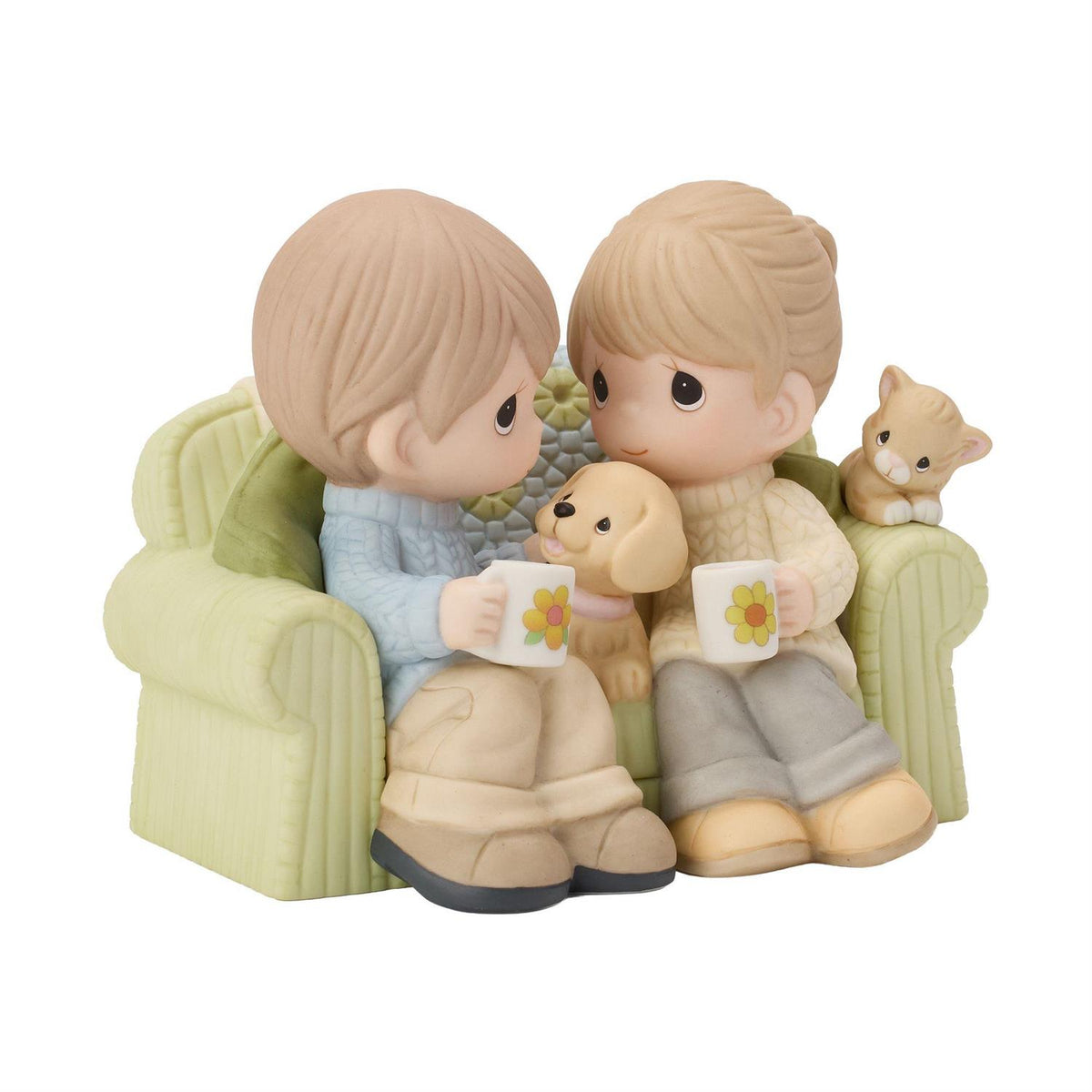 A couple sitting on the couch drinking coffee enjoying each others company along with a dog and cat