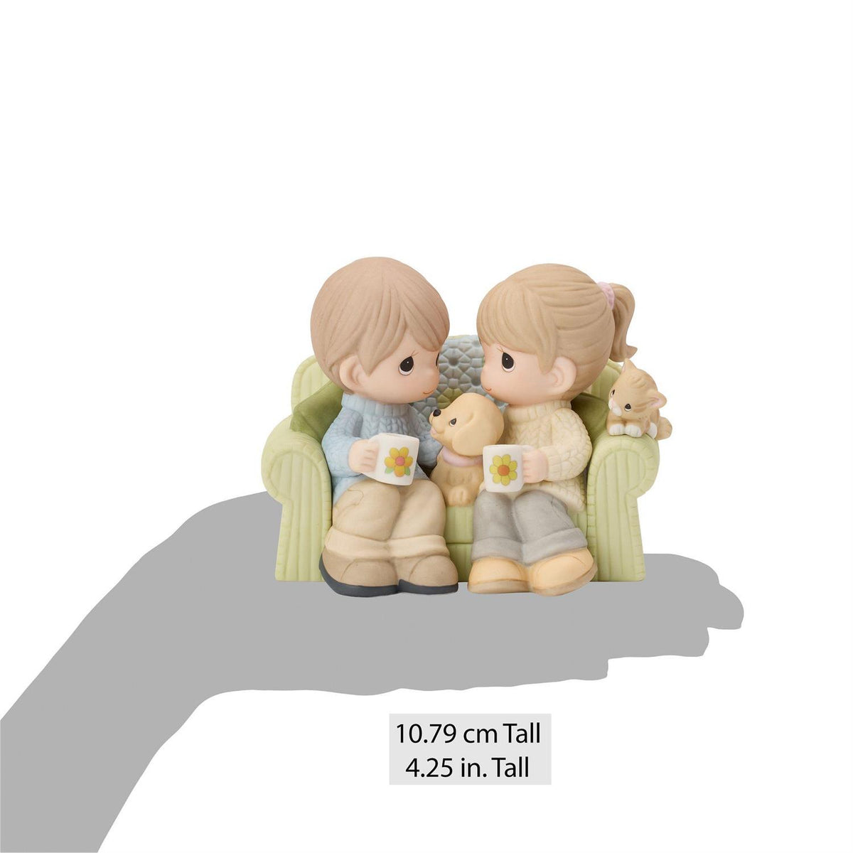 A couple sitting on the couch drinking coffee enjoying each others company along with a dog and cat