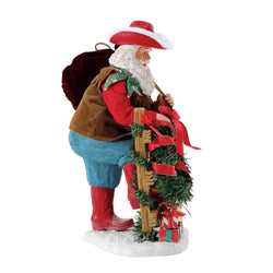 Buy Possible Dreams at CountryNMoreGIfts.com Santa standing next to a fence with a Cowboy hat on holding his toy bag over his shoulder