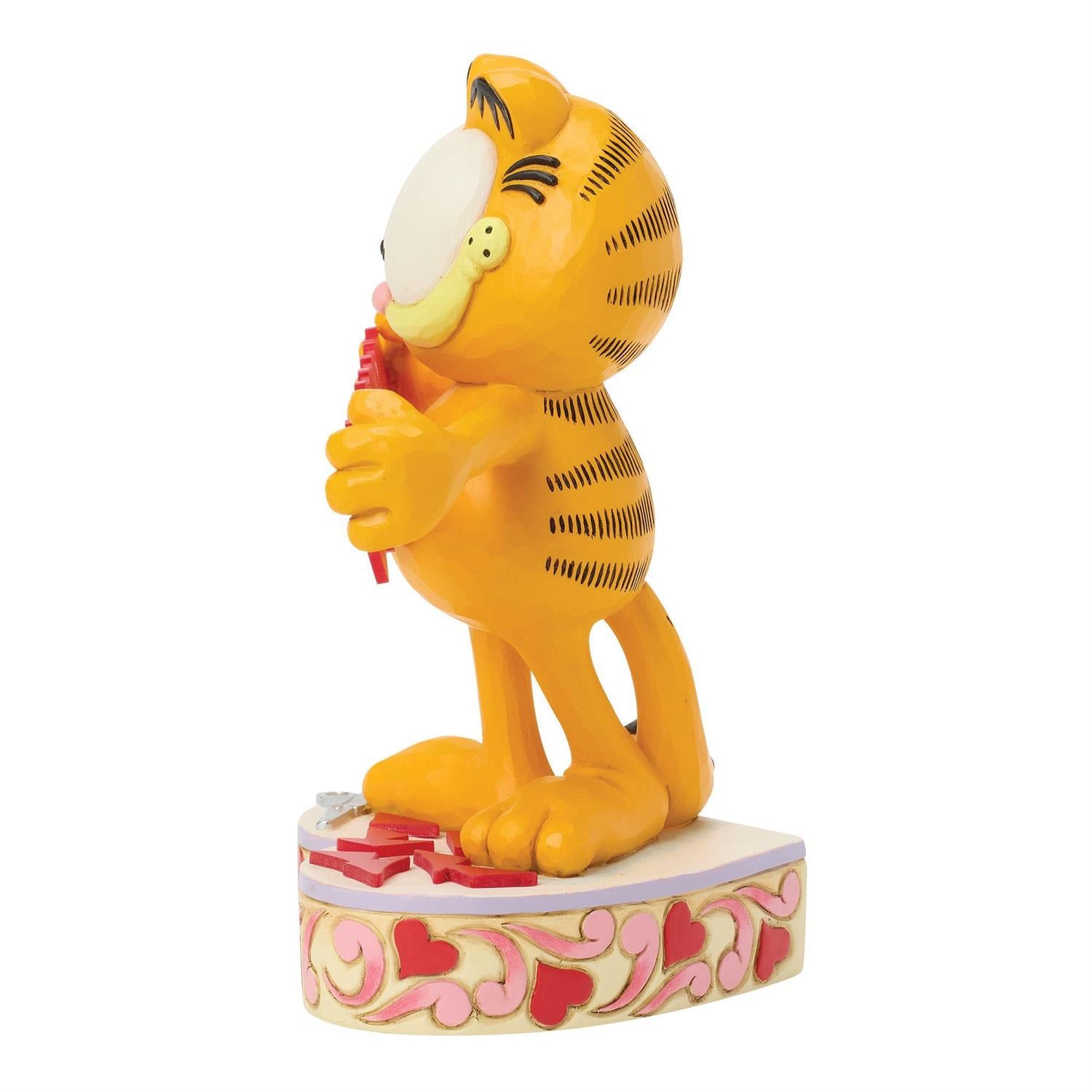 Garfield standing on a heart podium holding a string of hearts