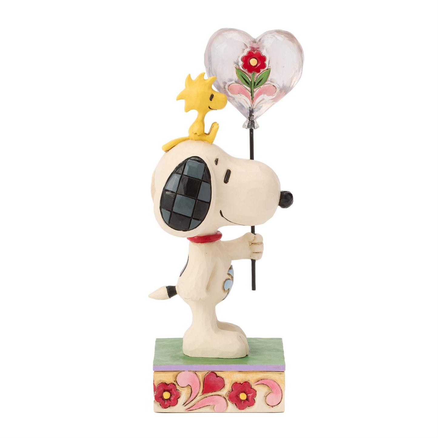Snoopy holding a heart balloon while Woodstock sitting on his head