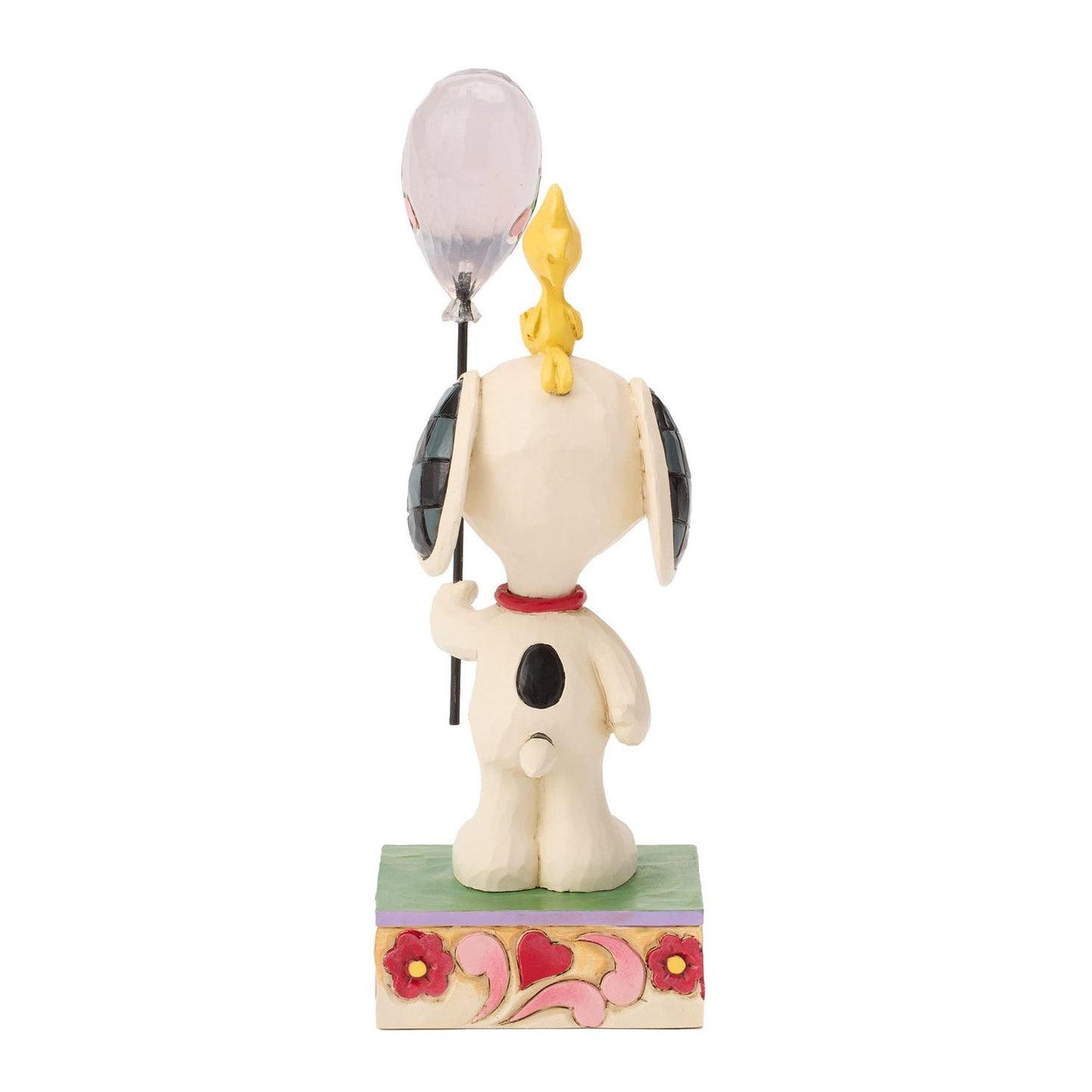 Snoopy holding a heart balloon while Woodstock sitting on his head