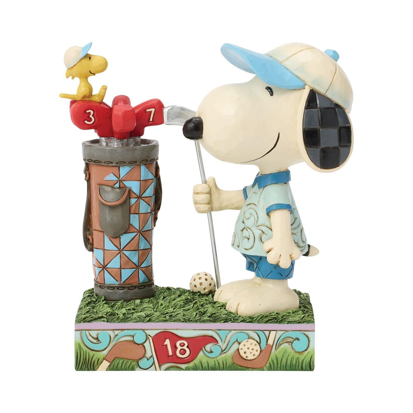 Snoopy dressed in his Golf clothes holding a Golf Club standing next to a Golf bag while Woodstock sits on the Golf Clubs and watches