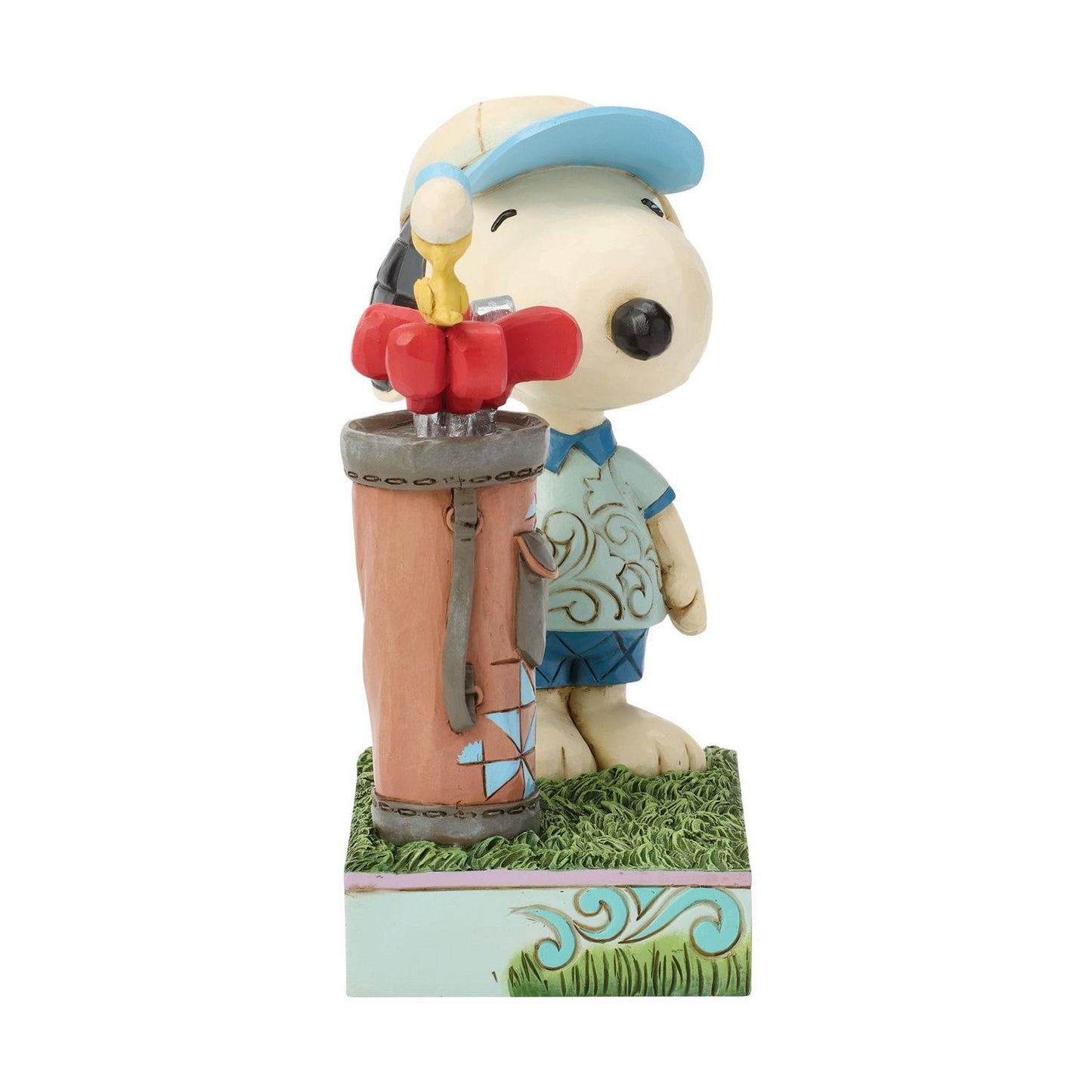 Snoopy dressed in his Golf clothes holding a Golf Club standing next to a Golf bag while Woodstock sits on the Golf Clubs and watches